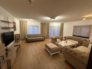 a living room with a couch and a tv at Apartmani Dalija in Sarajevo