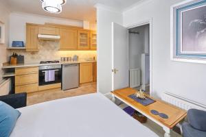 ブライトン＆ホーブにあるHost & Stay - Regency Square Apartmentのキッチン(ベッド1台、テーブル付) +4枚の写真