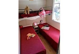 Cette chambre comprend deux lits superposés et un ours en peluche. dans l'établissement Feriendorf Le Tamerici Mobilehome Nuraghe für 6 Personen, à Marina di Cecina 22 autres photos