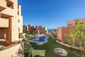 a courtyard with a swimming pool and umbrellas at Coto Real 2047 ANAFI in Manilva