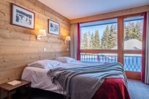 ein Schlafzimmer mit einem Bett und einem großen Fenster in der Unterkunft Résidence Pierre & Vacances Le Belmont in Arc 1800 + 45 Fotos