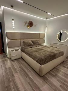 a bedroom with a large bed and a mirror at Wassal Compound in front of Madinatyah in Cairo