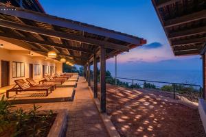una fila de bancos sentados en un patio con vistas al océano en Zostel Gokarna, en Gokarna