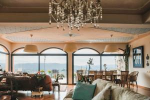 a living room with a chandelier and large windows at Villa Vernazza 5Terre & Versilia! in Castelnuovo Magra