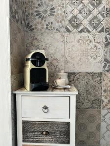 a white dresser with a coffee maker on top of it at Oasi Serena in Finale Ligure