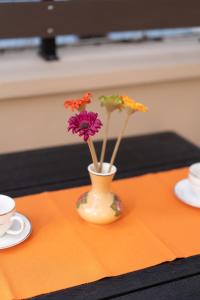 a vase with flowers in it on a table at Annas Cozy Stone House in Mytilini
