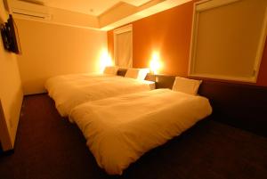 Postel nebo postele na pokoji v ubytování AB Hotel Kanazawa