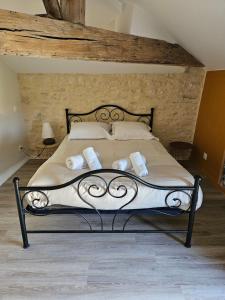 a bedroom with a bed with white sheets and pillows at maison de bourg au calme, proche du Futuroscope in Yversay