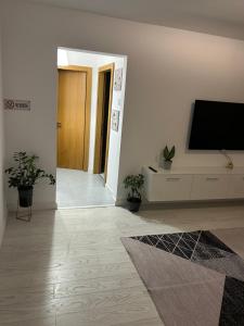 a living room with a flat screen tv on a white wall at Apartament Central in Râmnicu Vâlcea