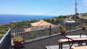 ein Balkon mit Tisch und Meerblick in der Unterkunft Paraiso das Flores in Estreito da Calheta