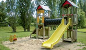 a playground with a slide in a park at Camping Les Fontaines in Ivry-la-Bataille