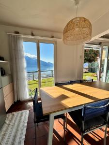 a dining room with a table and a large window at Casa Reto - Das Ferienhaus im Tessin in Gordola