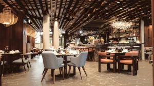 a restaurant with tables and chairs and a bar at Bellman Hotel in Berlin