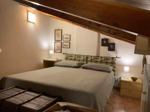 a bedroom with a large bed and two lamps at Appartamento mansardato centrale Limone Piemonte in Limone Piemonte