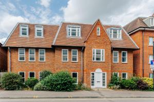 a large brick building with white doors and windows at StarHost Residences - Brand New 2 bed apartment in Newbury Centre in Newbury