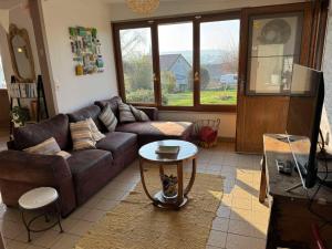 a living room with a couch and a table at Gîte Epis du Moulin in Étinehem