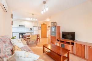 a living room with a couch and a tv and a table at Apartamento En Canet in Canet de Berenguer