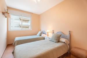 two beds in a small room with a window at Apartamento En Canet in Canet de Berenguer +26 photos