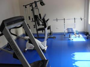 a gym with several tread machines on a blue floor at Hotel Aero Park e Estacionamento in Londrina