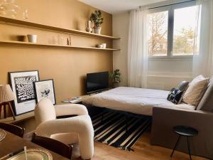 a bedroom with a bed and a chair and a window at Le pétillant champenois in Reims
