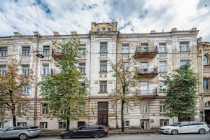 Un gran edificio con coches aparcados delante. en City Studio Apartment, en Vilna
