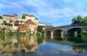a bridge over a river in front of a city at Le Domus Pesmois in Pesmes