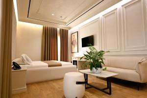 a hotel room with a bed and a couch at King & Queen Boutique Hotel in Fier