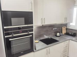 a kitchen with a black oven and white cabinets at 70m 2BR bright luxury apt in Athens +12 photos