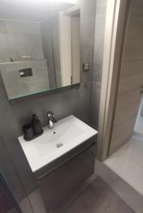 a bathroom with a white sink and a mirror at 70m 2BR bright luxury apt in Athens