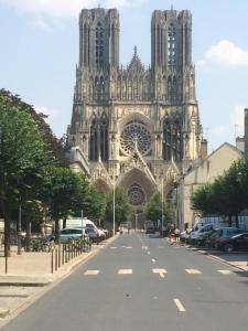 a large cathedral with a road in front of it at Le pétillant champenois in Reims