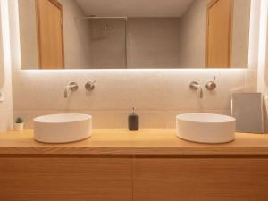 ein Badezimmer mit zwei Waschbecken und einem großen Spiegel in der Unterkunft Villa Calina prime location sea views in Son Bou