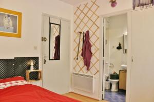 sypialnia z czerwonym łóżkiem i łazienką w obiekcie Studio classé 2 étoiles à 5 minutes du centre ville et 10 des Thermes w mieście Amélie-les-Bains-Palalda