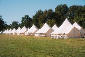 a row of white tents in a field at Silver - Glamping in Le Mans