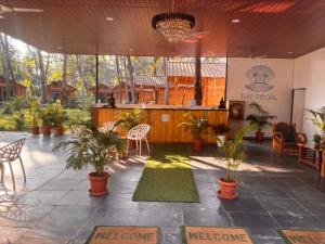 a patio with plants and a bar in a restaurant at The Pearl Beach Resort in Canacona