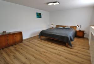 ein Schlafzimmer mit einem Bett und einem Holzboden in der Unterkunft Ferienhaus Alte Wagnerei Steinatal - Ühlingen-Birkendorf in Ühlingen-Birkendorf