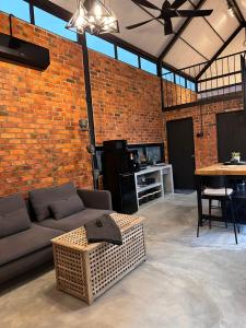 a living room with a couch and a brick wall at BRIC by The Hectar Private Pool Villa Janda Baik in Bentong +11 photos