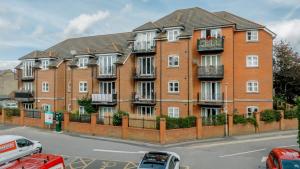 a large brick building with balconies on a street at StarHost Residences - Modern 2 bed apartment at Imperial Court, Newbury in Newbury