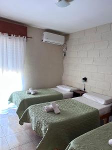 a room with three beds with towels on them at Casa Nuova - Depto SEIS in Villa Nueva