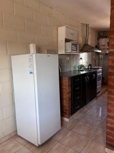 a kitchen with a white refrigerator in a room at Casa Nuova - Depto SEIS in Villa Nueva