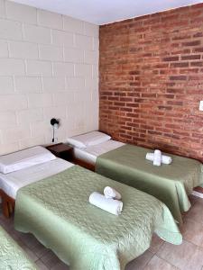 a room with three beds and a brick wall at Casa Nuova - Depto SEIS in Villa Nueva