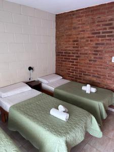 a room with three beds and a brick wall at Casa Nuova - Depto SEIS in Villa Nueva
