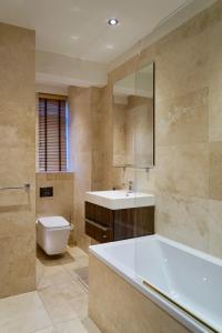une salle de bain avec une baignoire, un lavabo et des toilettes dans l'établissement Chelsea Prime Location Studio, à Londres