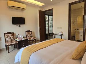 a bedroom with a large bed and a television at Two Green Park in New Delhi