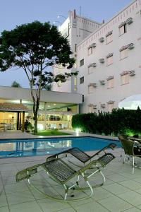 a swimming pool in front of a building at Hotel Aero Park e Estacionamento in Londrina