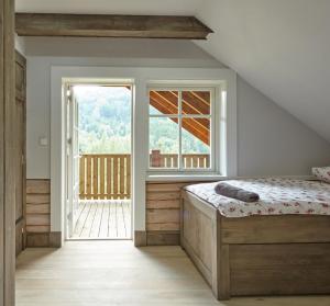 a bedroom with a bed and a large window at Obidza 438 chata w górach in Obidza +15 photos