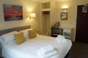a bedroom with a white bed with towels on it at The Barford Inn in Salisbury