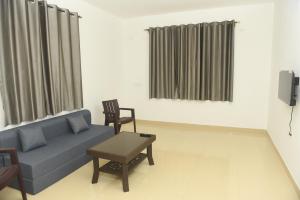 a living room with a couch and two chairs at Sai Homestay Panaji 2 BHK, 1 BHK and Studio Apartment in Panaji
