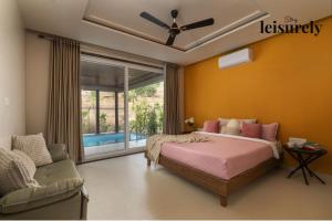 a bedroom with a bed and a couch and a window at Stay Leisurely Terra 2BHK & Timber 2BHK, Igatpuri in Balayaduri +39 photos