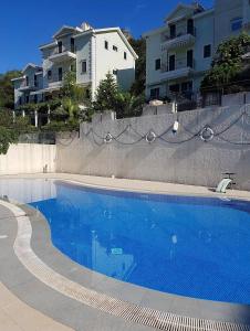 une piscine bleue en face de certains bâtiments dans l'établissement Green Village studio, à Gornji Orahovac
