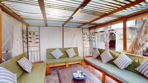 a screened in porch with a couch and a table at אחוזת ריצ'מונד של רשת לב הגולן - 3 סוויטות מהממות בחד נס ליד הכנרת עם בריכה משותפת מחוממת ומקורה in Had Nes